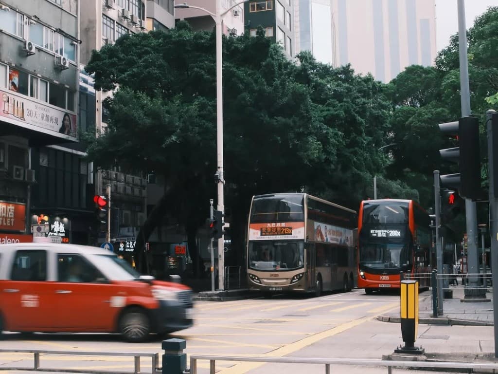 Hong Kong street: double-decker buses and a motion-blurred taxi