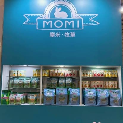 MOMI Animal Health — exhibition wall with MOMI rabbit logo and backlit shelving of hay and treat lines